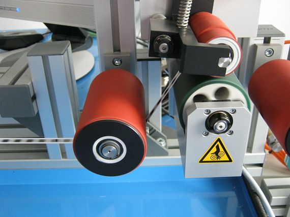 Conveyor rollers with xiros ball bearings in adhesive seal printers