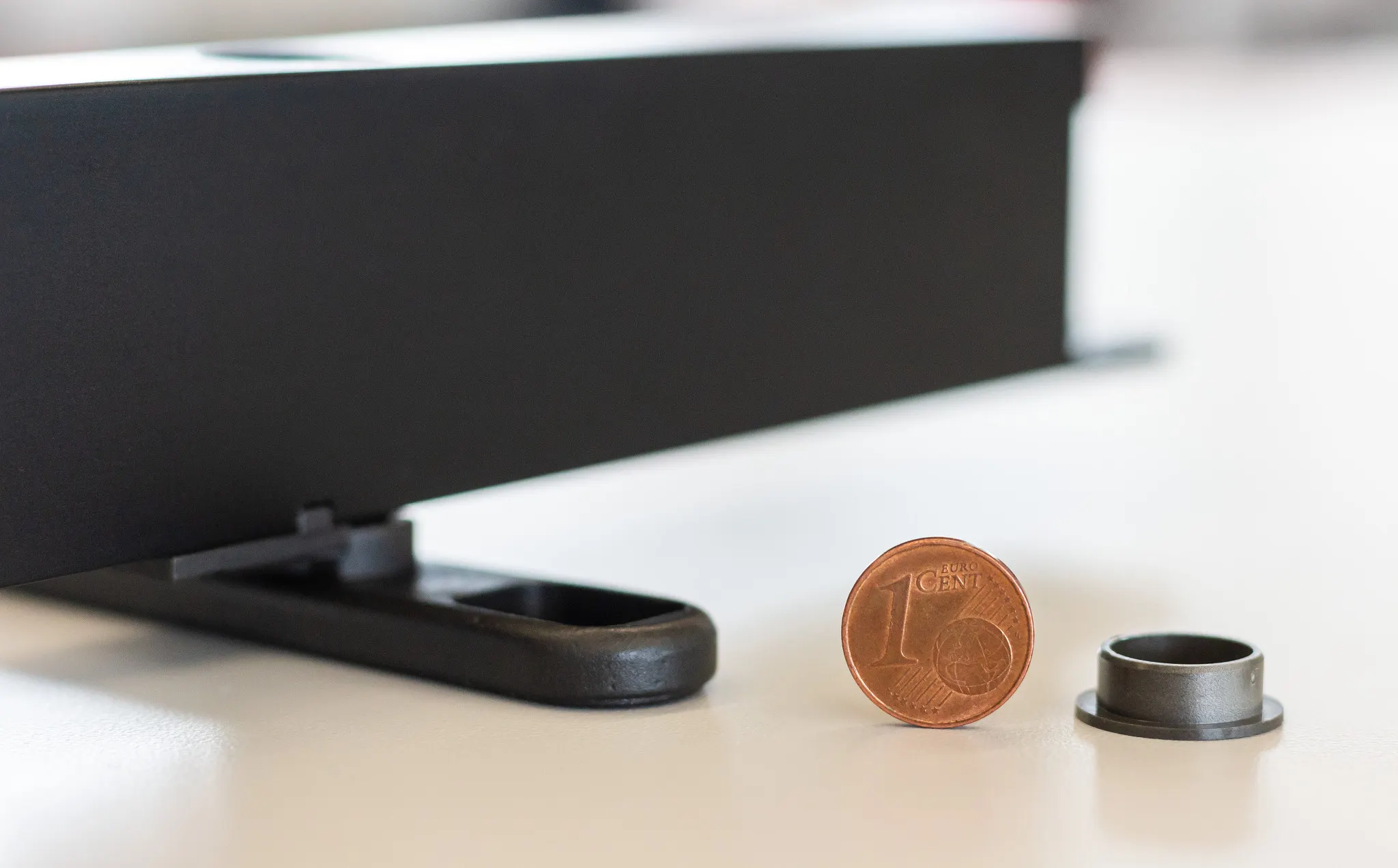 Scharniersysteem van de draaideur naast een muntstuk van één cent en het gebruikte iglidur® glijlager