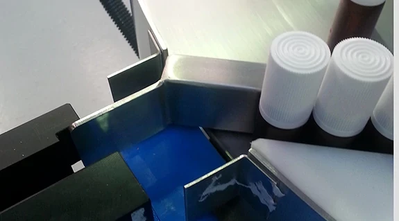 Spray bottles on a conveyor line being guided through the use of tribotape anti-friction tape