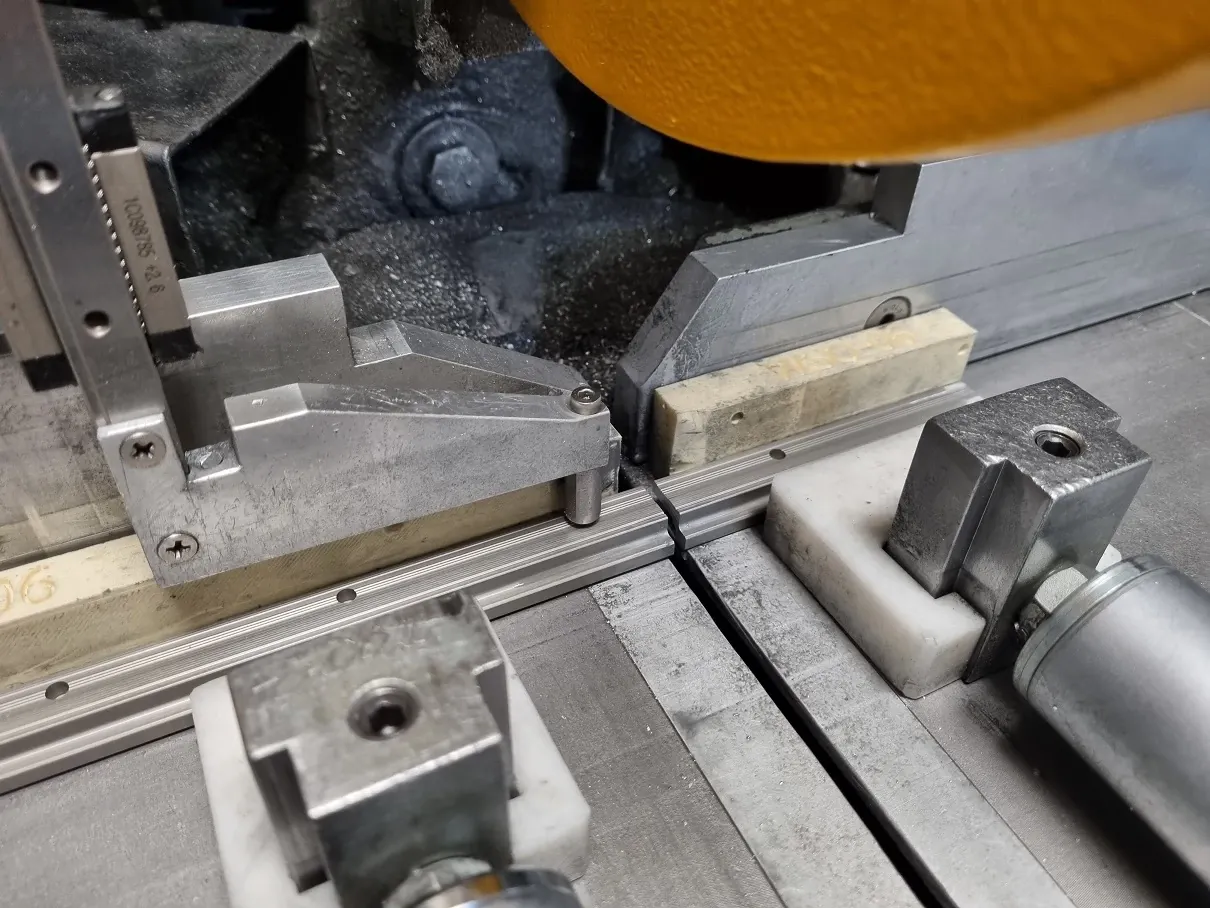 The 3D printed fixture holds the rails at right angles to the tapered pin, ensuring accurate sawing of the rails.