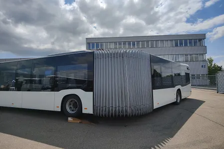 Ansicht eines Gelenkbusses, der um die Kurve fährt