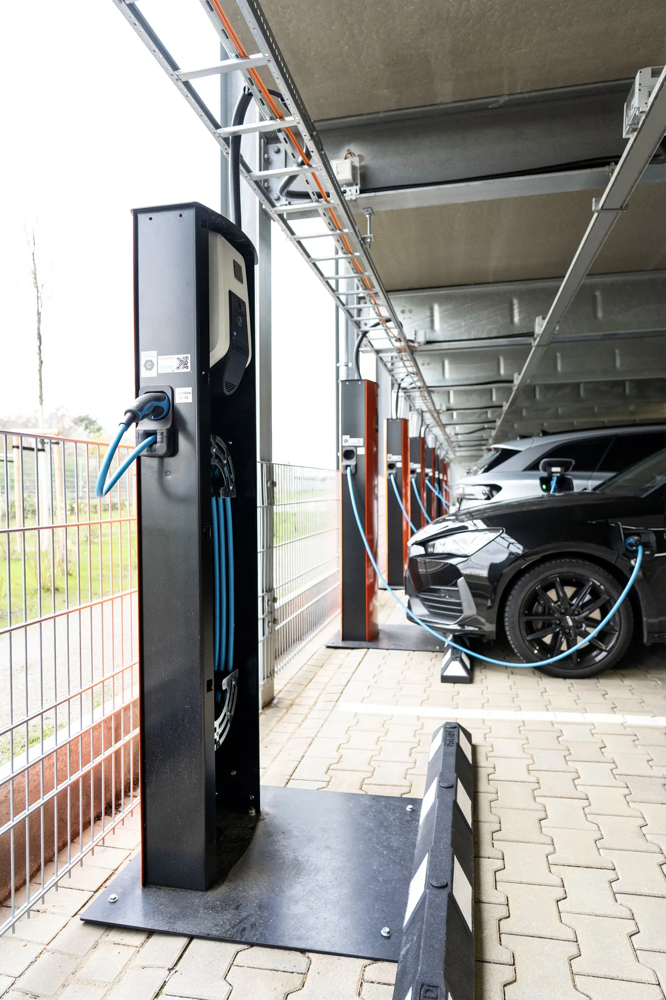 Autos in Garage, die an e-tract E-Ladesäulen angeschlossen sind