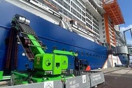 Seitenansicht eines Kreuzfahrtschiffes am Hafen, das an ein iMSPO-Ladesystem angeschlossen ist
