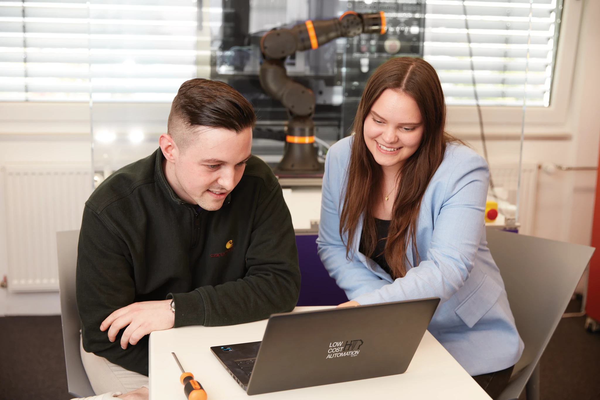 vrouwen die een robot programmeren